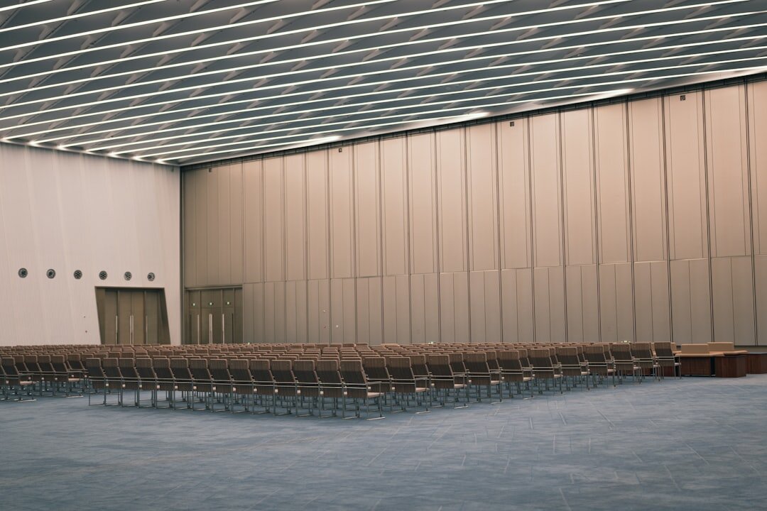 Large modern conference hall filled with seated attendees facing a big screen