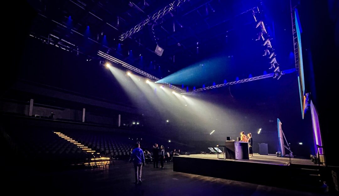 Speaker at a podium during an evening awards gala with dramatic stage lighting